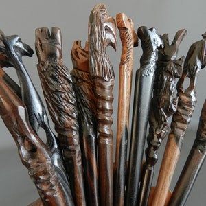 May include: A collection of intricately carved wooden sticks with various animal and bird designs. The sticks are dark brown and black with intricate details.