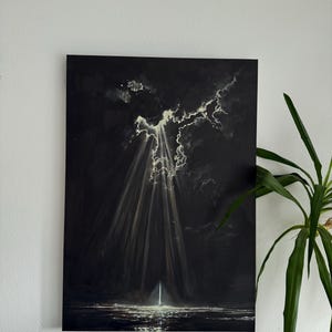 Könnte beinhalten: Ein Originalgemälde, das eine dramatische Szene von Licht zeigt, das durch dunkle Wolken bricht. Das Kunstwerk zeigt eine dunkle Farbpalette mit hellen, fokussierten Lichtstrahlen, die ein Gewässer beleuchten. Das Gemälde ist an einer Wand befestigt.