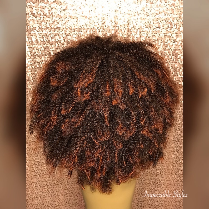 Puede incluir: Una peluca afro marr&oacute;n y naranja con rizos apretados. La peluca est&aacute; en una cabeza de maniqu&iacute;.