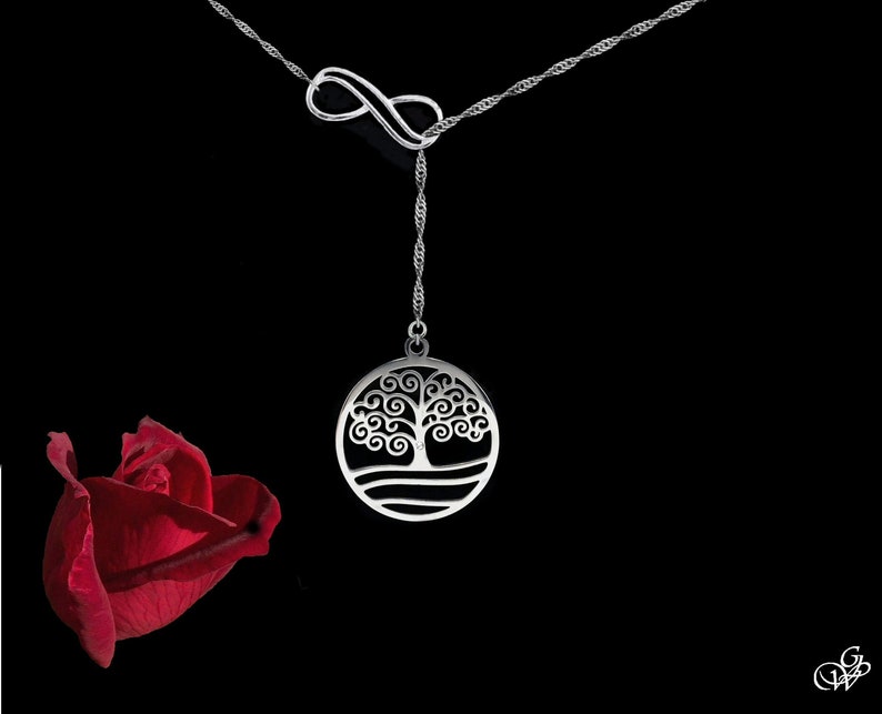May include: A silver necklace with an infinity symbol and a pendant featuring a tree of life design. The pendant is round and has a detailed outline of a tree with swirling branches.