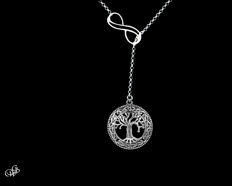 May include: A silver necklace with an infinity symbol at the top and a tree of life pendant hanging from it.