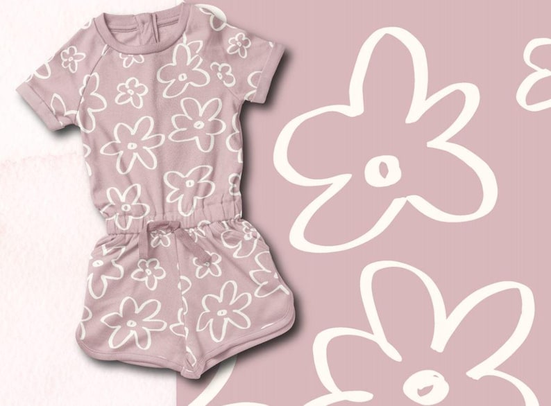 May include: A dusty rose-colored baby onesie with a white floral pattern. The onesie has short sleeves and a drawstring waist.