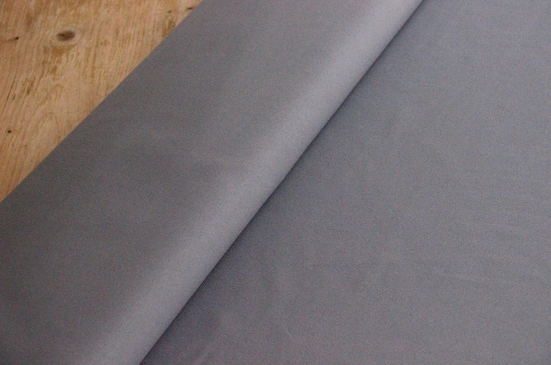 May include: A close-up of a piece of gray fabric. The fabric has a smooth, slightly textured surface.