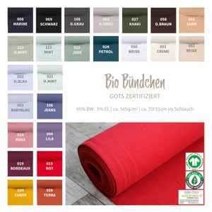 Könnte beinhalten: Ein roter Stoffmuster, aufgerollt mit einem weißen Etikett, auf dem "Bio Bündchen GOTS ZERTIFIZIERT 95% BW 5% EL | ca. 165g/m² | ca. 70/35cm im Schlauch" steht, und einem grün-weißen Etikett mit dem Text "ORGANIC 100 content standard" und "OEKO-TEX® MADE IN GREEN".