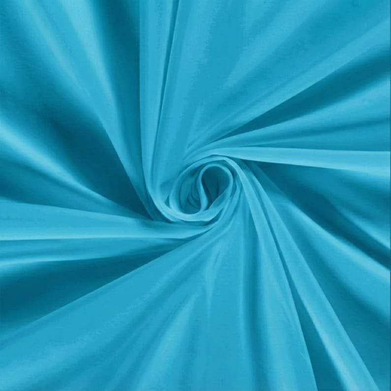 Pu&ograve; includere: Primo piano di un tessuto turchese vibrante con una lucentezza serica. Il tessuto &egrave; artisticamente drappeggiato e arricciato, creando un motivo dinamico di luci e ombre. Le pieghe e le curve del materiale aggiungono profondit&agrave; e consistenza all'immagine.