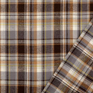 May include: Close-up of a plaid fabric in shades of brown, gray, white, and yellow. The pattern features intersecting lines creating a grid-like design. The fabric is folded over, revealing the reverse side with a similar pattern.