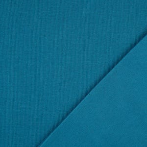 May include: Close-up of two pieces of teal fabric. The fabric on the left has a ribbed texture, while the fabric on the right is smooth. The two pieces are angled against each other, creating a diagonal line.