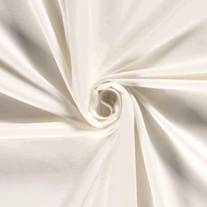 May include: White fabric with a smooth, silky texture. The fabric is draped and folded to create a swirling pattern.