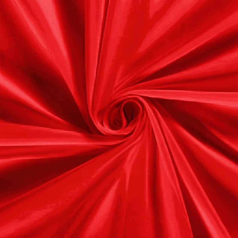 Pu&ograve; includere: Primo piano di un tessuto rosso vibrante, arricciato per creare un effetto a spirale. Il materiale ha una consistenza liscia e lucida, con la luce che si riflette sulle pieghe e sulle curve. L'impressione generale &egrave; di lusso e movimento.