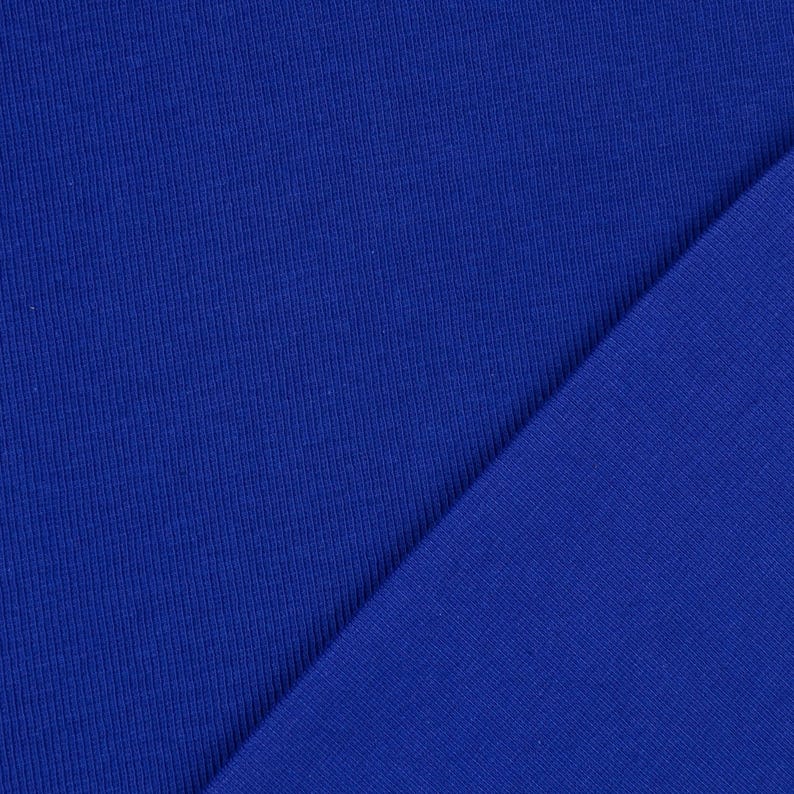 May include: Close-up of two pieces of royal blue fabric. One piece has a ribbed texture, while the other is smooth. The fabrics are angled against each other, showcasing the contrast in texture and color.
