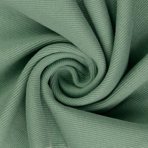 May include: Close-up of a sage green ribbed knit fabric. The fabric is tightly woven with vertical ridges, creating a textured surface. The fabric is folded and swirled, showing the depth and drape of the material. The color is a muted, earthy green.