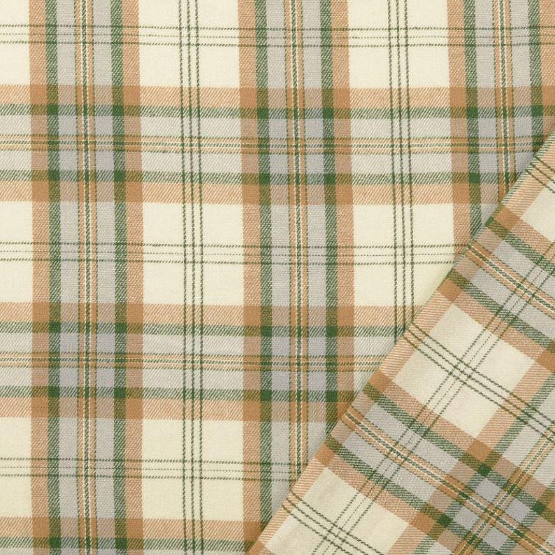 May include: Cream-colored plaid fabric with a repeating pattern of tan, green, and gray lines. The fabric is folded over, revealing the pattern on both sides. The fabric is suitable for sewing projects.