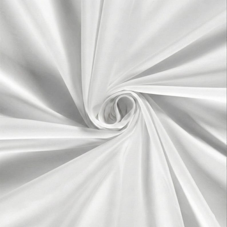 Pu&ograve; includere: Primo piano di un tessuto bianco, disposto in un motivo a spirale. Il tessuto ha una consistenza liscia e fluida, con ombre morbide e riflessi che ne esaltano le pieghe e le curve. L'effetto complessivo &egrave; di eleganza e fluidit&agrave;.