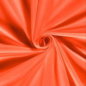 Pu&ograve; includere: Primo piano di un tessuto arancione vibrante, disposto a spirale. La trama liscia del tessuto e il gioco di luci e ombre creano un senso di profondit&agrave; e movimento. Il colore &egrave; una tonalit&agrave; calda e brillante.