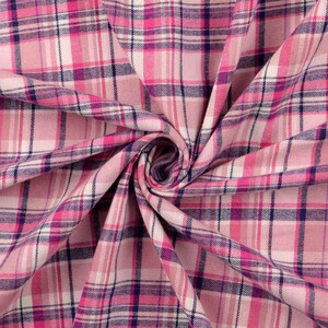 May include: Pink plaid fabric with a pattern of intersecting lines in shades of pink, white, and navy blue. The fabric is folded and draped, creating a textured appearance. This material is suitable for sewing projects.