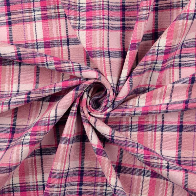 May include: Pink plaid fabric with a pattern of intersecting lines in shades of pink, white, and navy blue. The fabric is folded and draped, creating a textured appearance. This material is suitable for sewing projects.