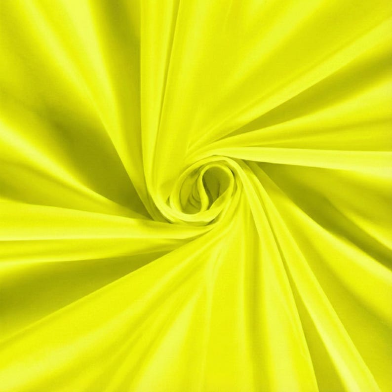 Pu&ograve; includere: Primo piano di un tessuto giallo brillante, disposto a spirale. La trama liscia e il colore vivace creano un effetto visivo dinamico. Le pieghe e le curve del materiale aggiungono profondit&agrave; e dimensione all'immagine.