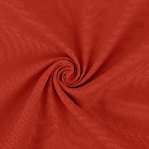 May include: Close-up of a red fabric with a textured surface. The fabric is folded and twisted, creating a swirling pattern.
