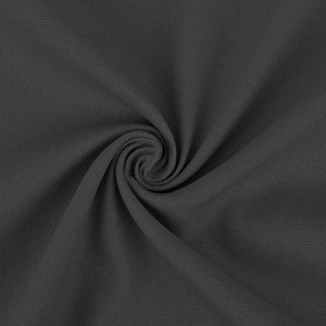 May include: A close-up of a dark gray fabric with a textured surface. The fabric is folded and twisted, creating a swirling pattern.