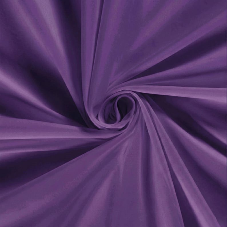 Pu&ograve; includere: Primo piano di un tessuto drappeggiato a spirale in una tonalit&agrave; viola intenso. Il tessuto ha una consistenza setosa e liscia con pieghe e ombre visibili, creando un senso di profondit&agrave; e movimento. Il centro dell'immagine presenta una formazione a spirale.