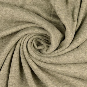 May include: Close-up of a swirl of soft, light gray fabric. The material is tightly woven, with visible texture and folds creating a dynamic pattern. The fabric appears to be a knit or jersey material, suitable for clothing.