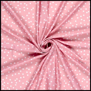 May include: Pink fabric with a white polka dot pattern. The fabric is folded and twisted, creating a swirling effect.