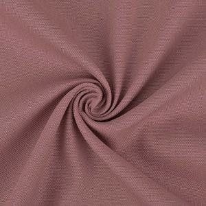 May include: A close-up of a soft, textured fabric in a dusty rose color. The fabric is folded and draped, creating a smooth, flowing effect.