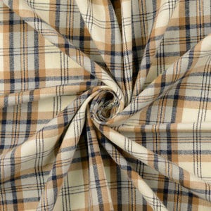 May include: Close-up of a beige, brown, and navy blue plaid fabric. The fabric is tightly woven with a classic plaid pattern. The fabric is folded and draped, showing the texture and color variations.