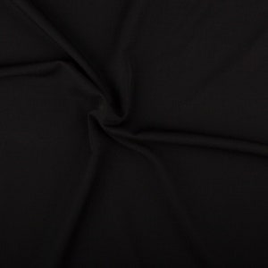Könnte beinhalten: Schwarzer Stoff mit einer glatten, weichen Textur. Der Stoff ist gefaltet und drapiert und erzeugt so ein Gefühl von Bewegung und Fließfähigkeit.