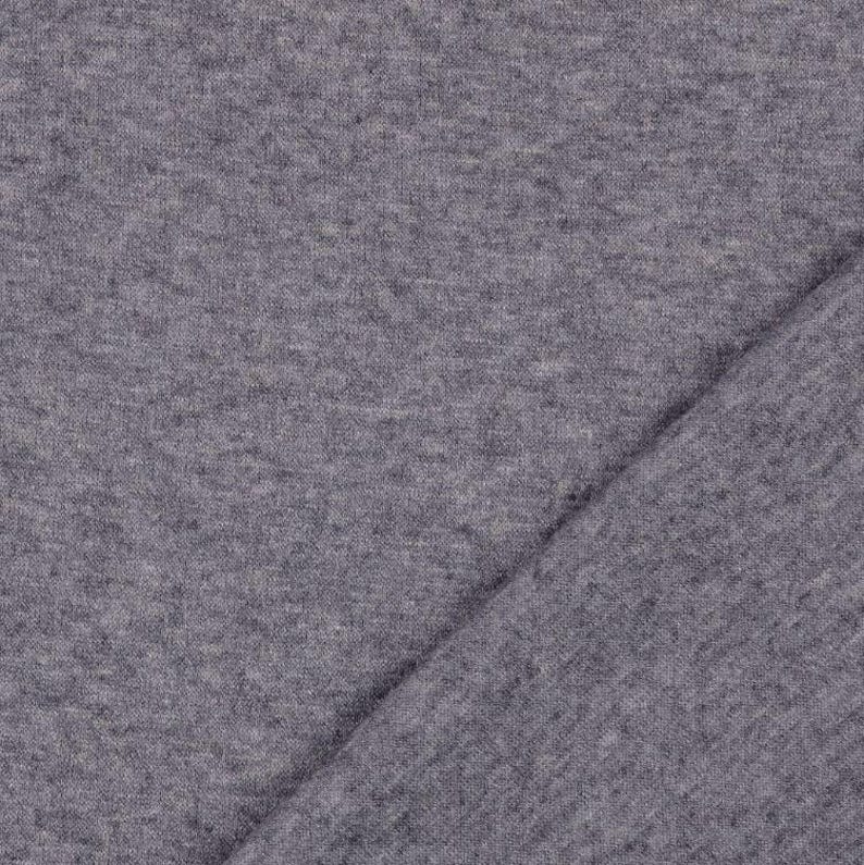 May include: Close-up of a gray fabric with a diagonal fold. The fabric has a textured appearance, with a slightly heathered effect. The color is a medium gray, suitable for various apparel or craft projects.