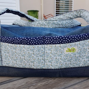Peut inclure: Un sac cabas en jean bleu avec une doublure à imprimé floral et une poche à imprimé étoiles bleues et blanches. Le sac a deux anses et une petite étiquette verte avec le texte "Le Sac à Main".