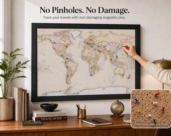 May include: A framed world map with a light beige background and black frame. The map features colorful magnetic pins placed on various countries. Text above the map reads: No Pinholes. No Damage. Track your travels with non-damaging magnetic pins.