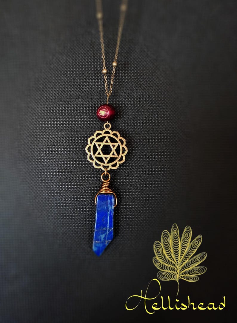 May include: Gold necklace with a red bead, a gold star of David charm, and a blue lapis lazuli pendant.