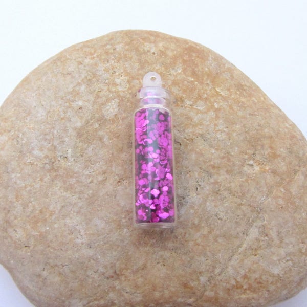 Grande fiole en verre remplie de paillettes fuchsia