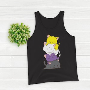 Op de afbeelding: Zwart mouwloos shirt met een ontwerp van vier cartoonkatten in geel, wit, paars en grijs. De katten zijn op elkaar gestapeld en lachen. Het mouwloze shirt is gemaakt van een zacht materiaal.