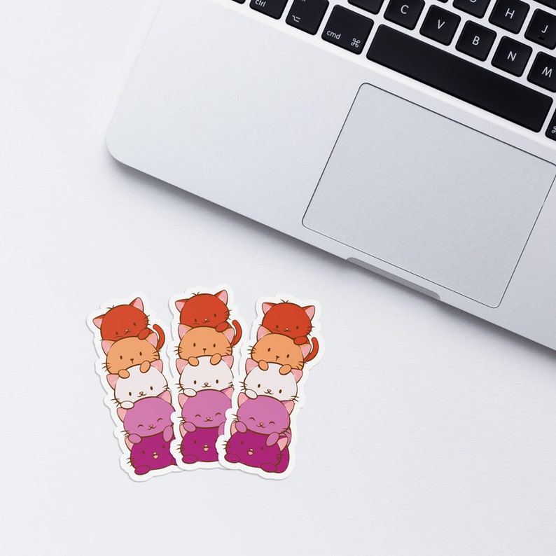 May include: Three stacks of cute cartoon cats with different colored fur. The cats are stacked in a gradient from orange to pink. The cats are all smiling and have big eyes.