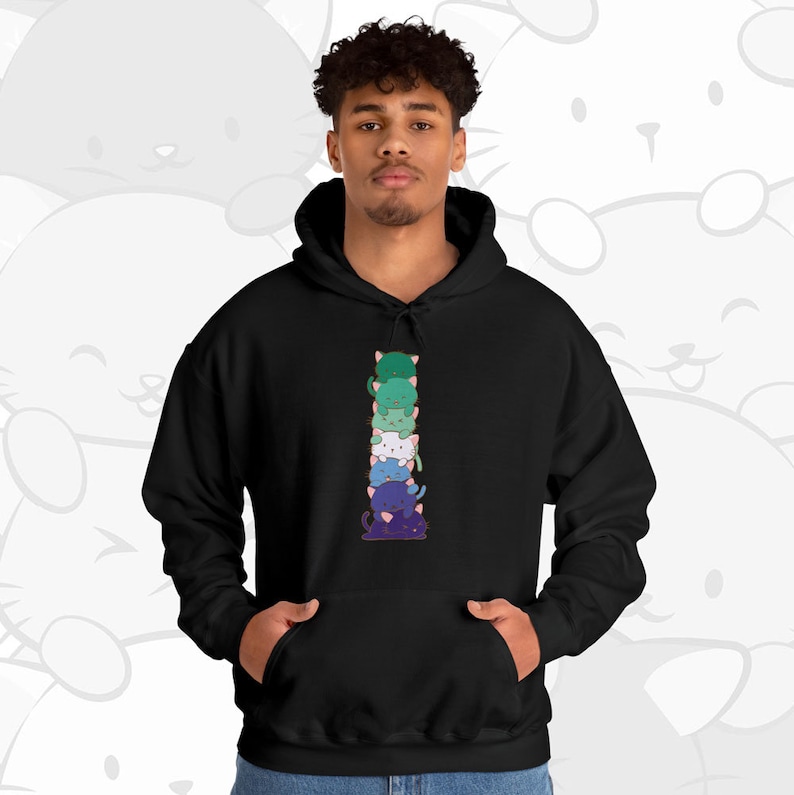 K&ouml;nnte beinhalten: Ein schwarzer Hoodie mit einem Aufdruck von sechs bunten Comic-Katzen, die auf dem Vorderteil &uuml;bereinander gestapelt sind. Die Katzen sind vertikal &uuml;bereinander gestapelt, wobei die unterste Katze lila, die n&auml;chste blau, dann wei&szlig;, gr&uuml;n und schlie&szlig;lich eine gr&uuml;ne Katze oben ist.
