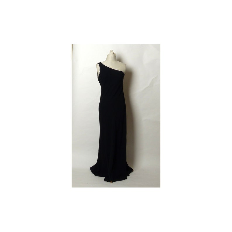 May include: A black one-shoulder evening gown with a long, flowing skirt.