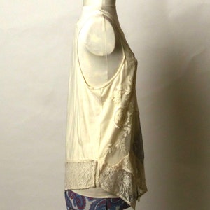 May include: A white sleeveless top with lace detailing and a paisley print on the bottom.