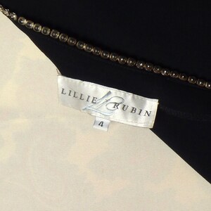 May include: White and black clothing label with the text "Lillie Rubin" and the number "4" printed on it.