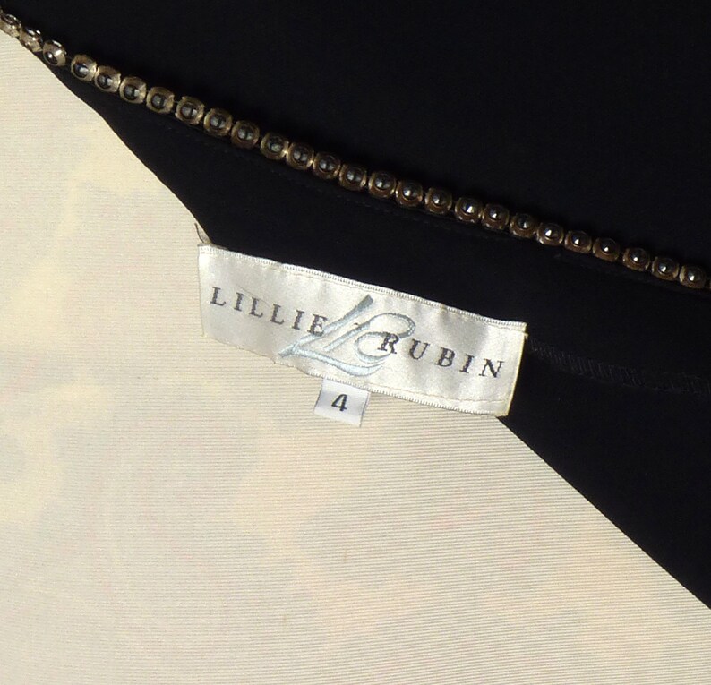 May include: White and black clothing label with the text "Lillie Rubin" and the number "4" printed on it.