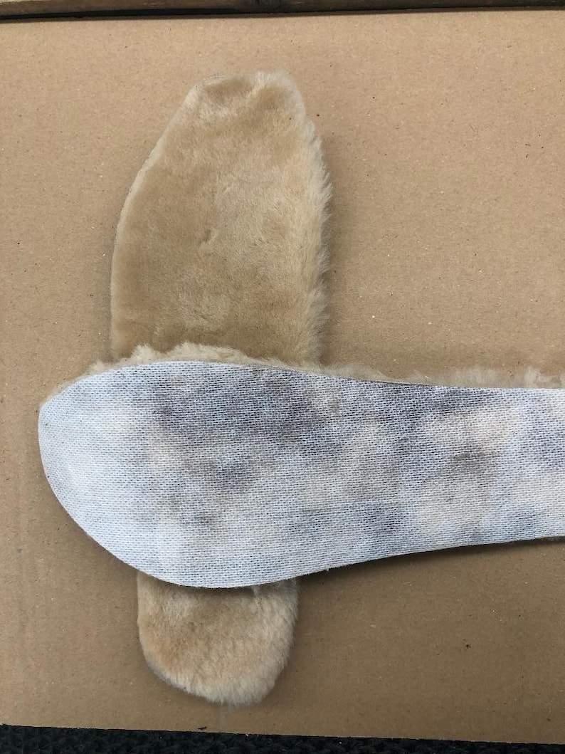 Puede incluir: Un par de plantillas de piel de oveja beige con un respaldo de malla blanca. Las plantillas est&aacute;n dise&ntilde;adas para brindar calidez y comodidad.