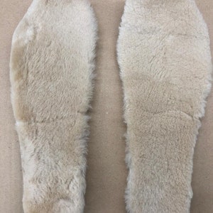 Puede incluir: Dos plantillas de piel de oveja beige para zapatos o botas.