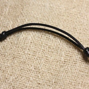 May include: A black cord necklace with a simple knot closure.
