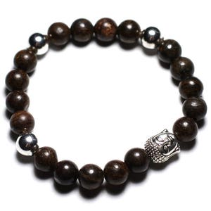 May include: A brown wooden beaded bracelet with silver accents and a silver Buddha head charm.