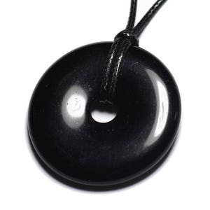 Peut inclure: Pendentif en forme de beignet en obsidienne noire sur un collier en cordon noir. Le pendentif est lisse et poli avec un trou au centre.