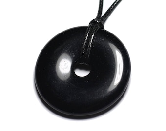 Könnte beinhalten: Schwarzer Obsidian-Donut-Anhänger an einer schwarzen Kordelkette. Der Anhänger ist glatt und poliert mit einem Loch in der Mitte.