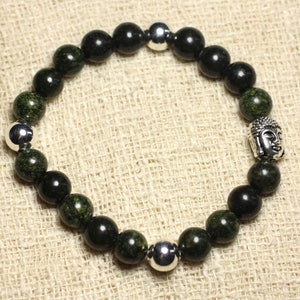 Peut inclure: Un bracelet en perles noires et vertes avec des accents argentés. Le bracelet présente un charme tête de Bouddha.