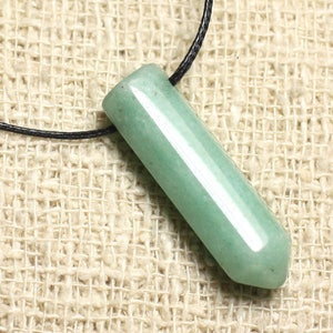 Pode incluir: Pingente de pedra preciosa verde claro, com formato cilíndrico e ponta. O pingente está preso a um fino cordão preto. A pedra preciosa tem uma superfície lisa e polida. Joia.