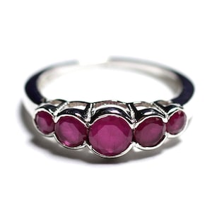 Peut inclure: Une bague en argent avec cinq pierres précieuses rondes en rubis serties en rangée.